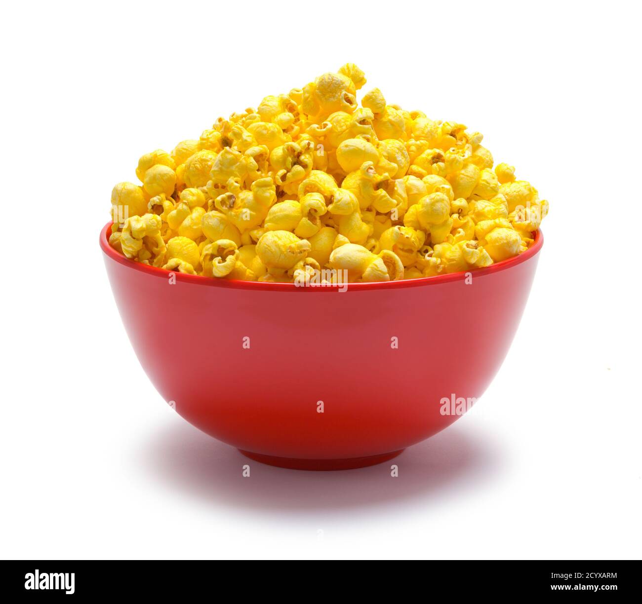 Rote Schale voll Popcorn isoliert auf Weiß. Stockfoto