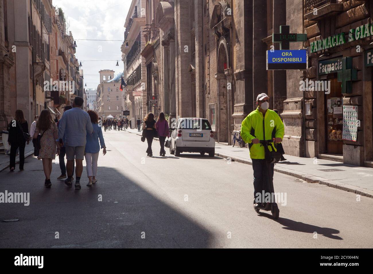 ROM, ITALIEN - OKTOBER 01 2020: In Romes Via del Corso, Italien, fährt ein Mann mit einer schützenden Gesichtsmaske auf einem Elektroroller. Stockfoto