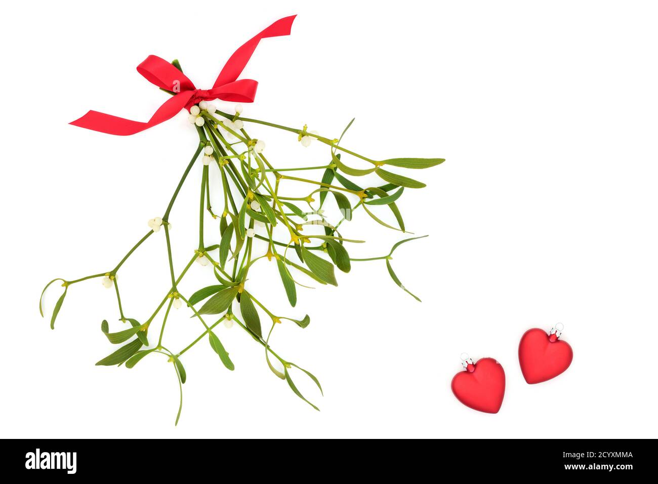 Mistel Bund mit einer Schleife & zwei rote Herz-Kugel Dekorationen symbolisieren Liebe auf weißem Hintergrund gebunden. Romantisches Konzept für die Wintersonnenwende & fe Stockfoto
