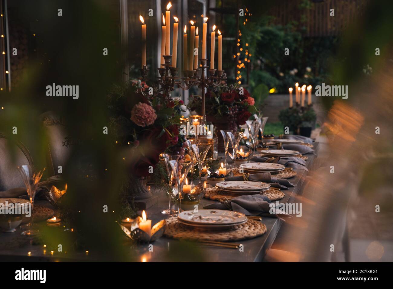 Weihnachtstisch mit Blumen, Früchten, Kerzen und Gläsern. Stockfoto