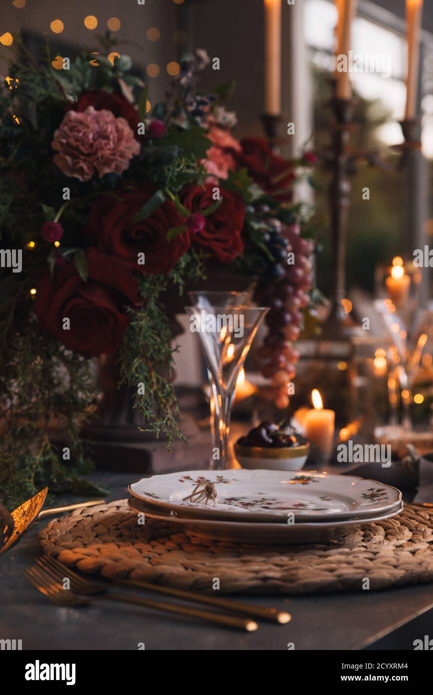 Weihnachtstisch mit Blumen, Früchten, Kerzen und Gläsern. Stockfoto