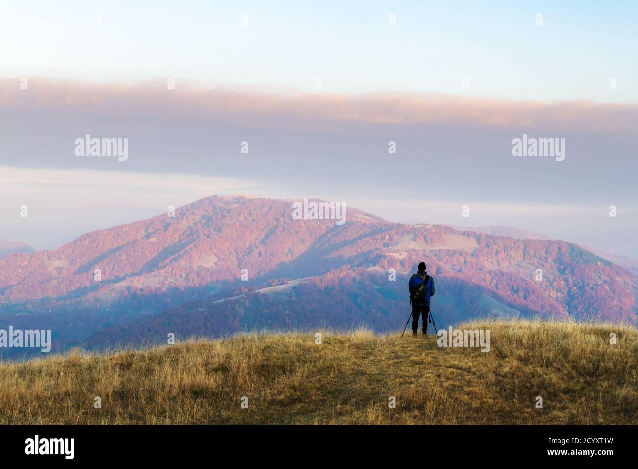 Fotograf fotografiert mit Stativ der herbstlichen Landschaft mit nebligen Gipfeln und Orangenbäumen. Ukrainische Karpaten Berge Stockfoto
