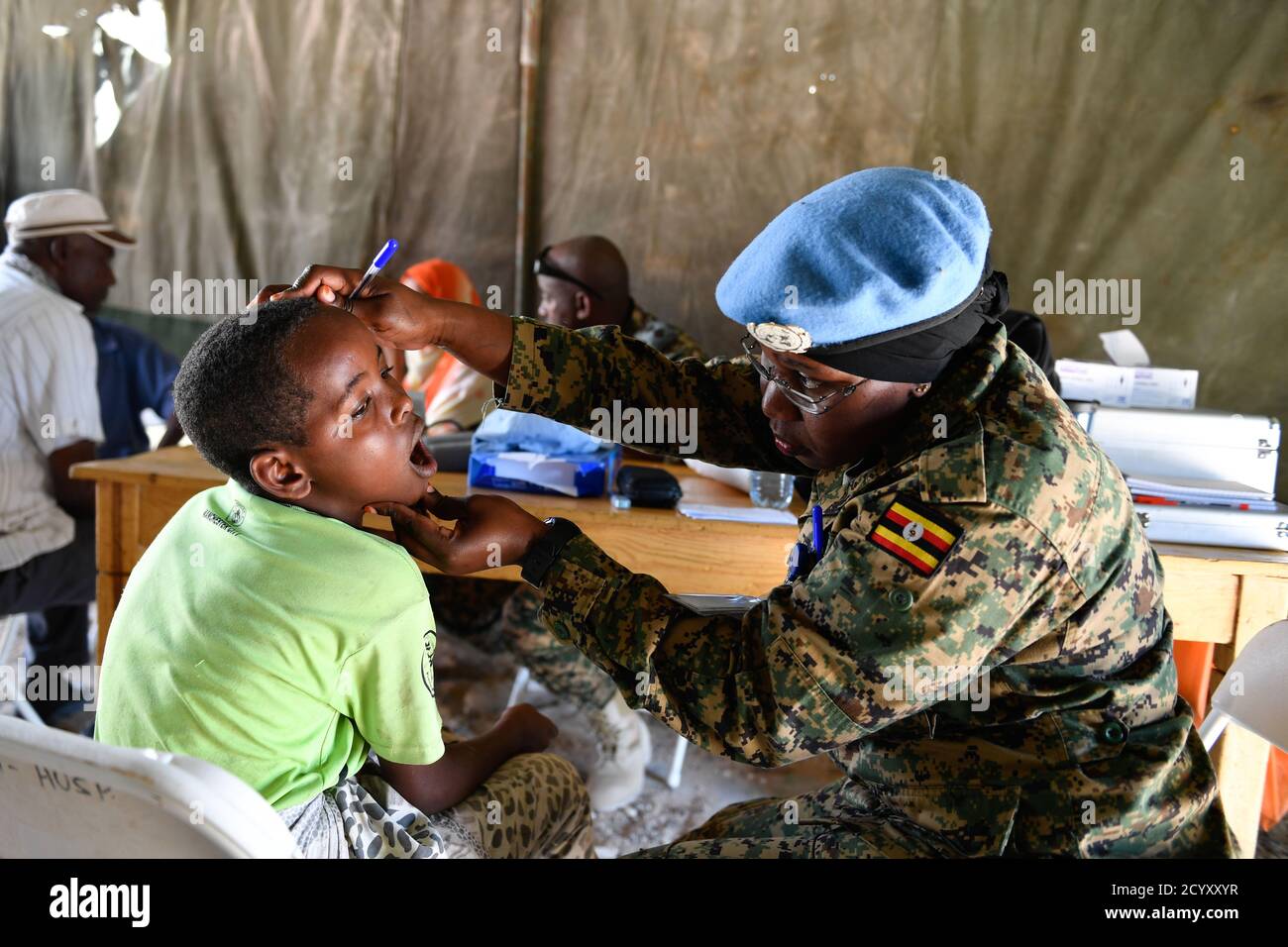 Ein ugandischer Militäroffizier, der unter der UN-Schutzeinheit in Somalia dient, betreut am 06. Februar 2019 ein krankes Kind in einem ambulanten medizinischen Lager in Mogadischu, Somalia. Dies war Teil der Aktivitäten, die das ugandische Militär anlässlich des "Tarehe Sita"-Tages anlässlich des 38. Jahrestages der Gründung der ugandischen Volksverteidigungskräfte (UPDF) am 06. Februar 1981 organisierte. Stockfoto