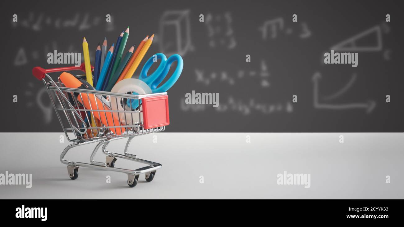 Zurück in die Schule, Schüler Sachen in Shopping Trolley, Board im Hintergrund Stockfoto