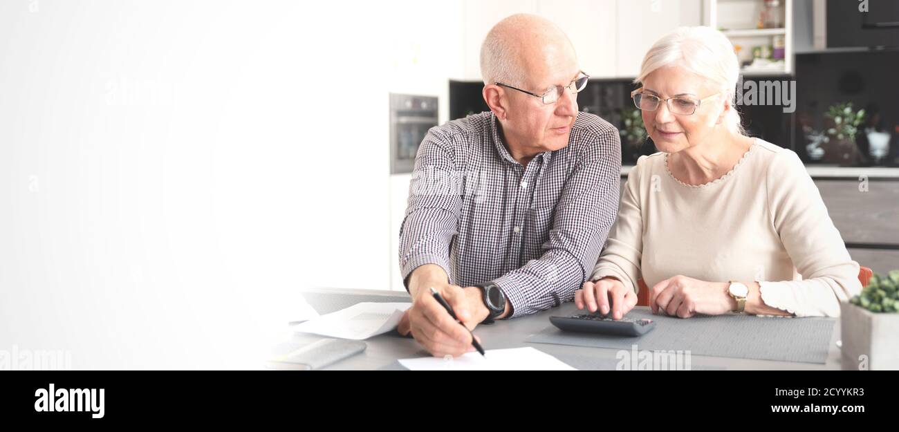Seniorenpaar berechnet gemeinsam das Budget. Rentner zahlen die Rechnungen. Web-Banner-Bild Hintergrund mit Kopierplatz. Stockfoto