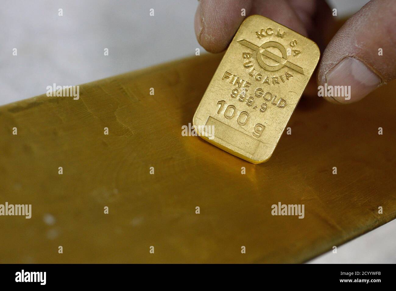 Ein Mitarbeiter von Bulgariens größten Zink und Blei Schmelze, KCM, zeigt  eine 100 g Gold Platte und ein 13 kg gold Barren in der Nähe der Stadt von  Plovdiv 20. Oktober 2011.