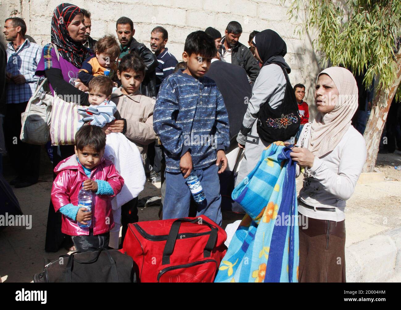 Syrischen Familien verlassen die belagerte Stadt von al-Mouadamiya, die durch Oppositionskämpfern gesteuert wird, in Damaskus Landschaft 29. Oktober 2013. Ein seltener Moment der Koordinierung zwischen der syrischen Regierung und Rebellen aktiviert 1.800 Zivilisten, eine belagerte Stadt am Rande von Damaskus am Dienstag zu fliehen, aber Tausende mit wenig Nahrung, Wasser oder Medizin gefangen bleiben. Eine Quelle im Ministerium für soziale Angelegenheiten sagte, dass die Evakuierung von Mouadamiya mit Hilfe von dem syrischen arabischen roten Halbmond und einigen zivilen Gruppen voraus gegangen war. REUTERS/Khaled al-Hariri (Syrien - Tags: Politik Konflikt Unruhen Stockfoto