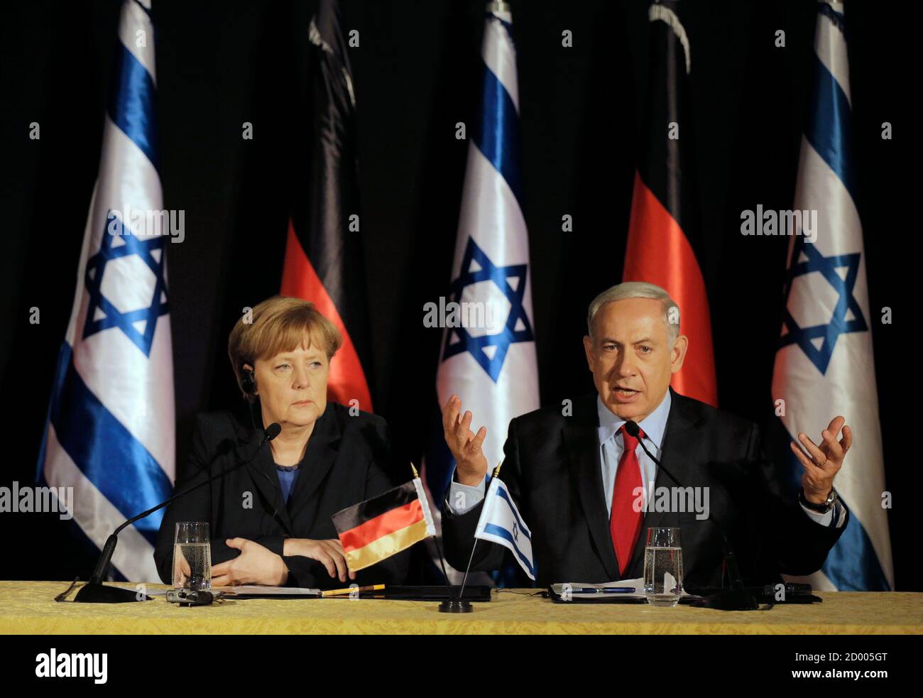 Israels Prime Minister Benjamin Netanyahu (R) sitzt neben Bundeskanzlerin Angela Merkel, als er während der gemeinsamen Pressekonferenz in Jerusalem 25. Februar 2014 spricht. Deutschland sieht Iran als eine potenzielle Bedrohung nicht nur für Israel, aber auch in europäische Länder, Merkel, sagte am Dienstag auf einer gemeinsamen Pressekonferenz mit Netanyahu. REUTERS/Ammar Awad (JERUSALEM - Tags: Politik) Stockfoto