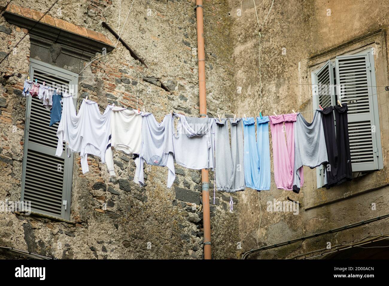 Traditionelle italienische Art, Wäsche zu trocknen, die an der Schlange  hängt Der Wind zwischen den Fenstern Stockfotografie - Alamy