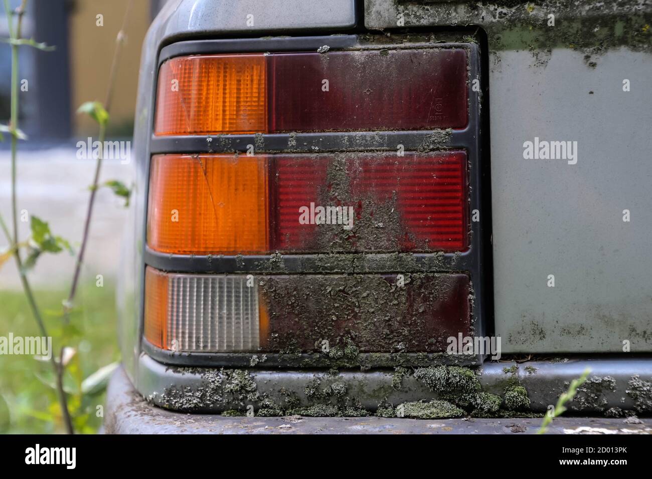 Verlassene 80er Jahre Autoscheinwerfer voller Moos staubig verrostet Nahaufnahme. Stockfoto
