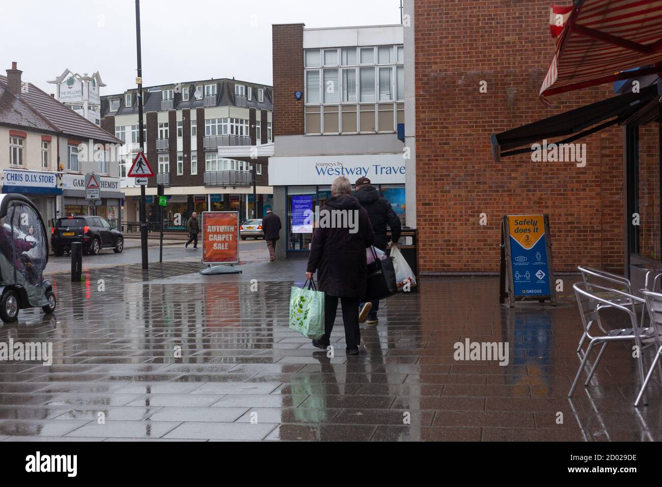 Straßenszene - Rückansicht von zwei Frauen mit Einkaufstaschen, Wickford High Street, Essex, Großbritannien Stockfoto