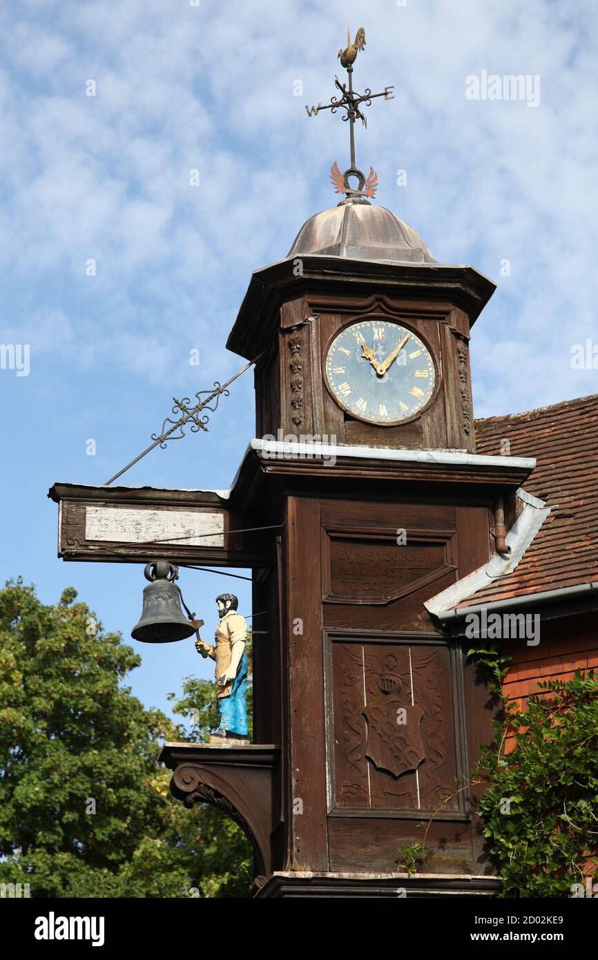 Abinger Hammer Clock überhängt die Hauptstraße und stellt die Figur des "Jack der Schmied", in Erinnerung an den ersten Lord Farrer von Abinger Hall Wer Stockfoto