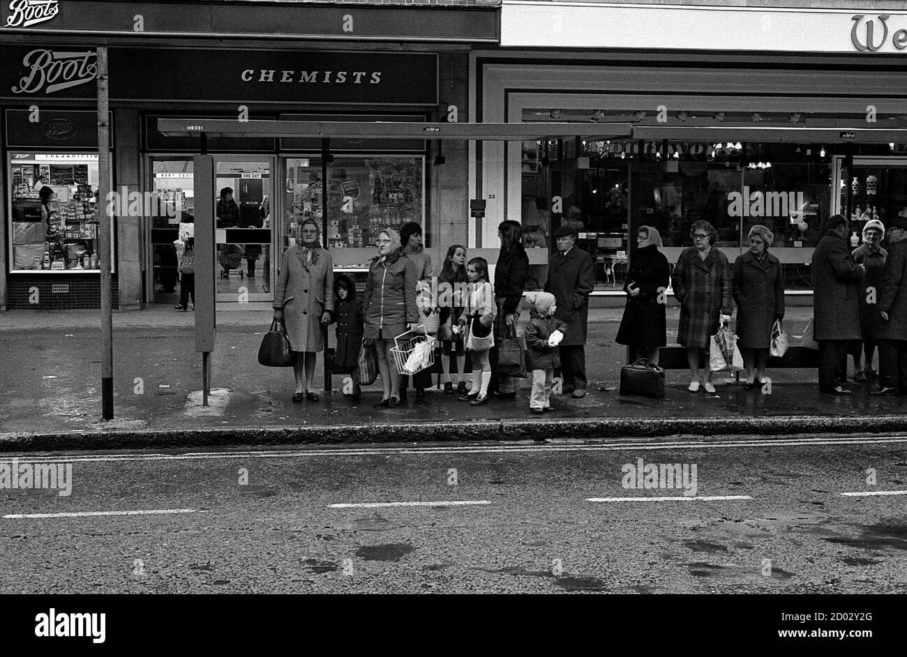 AJAXNETPHOTO. 1974. SOUTHSEA, ENGLAND. - WARTEN - SCHLANGE WARTEN AN DER BUSHALTESTELLE IN PALMERSTON ROAD.FOTO:JONATHAN EASTLAND/AJAX REF:1974 20 Stockfoto