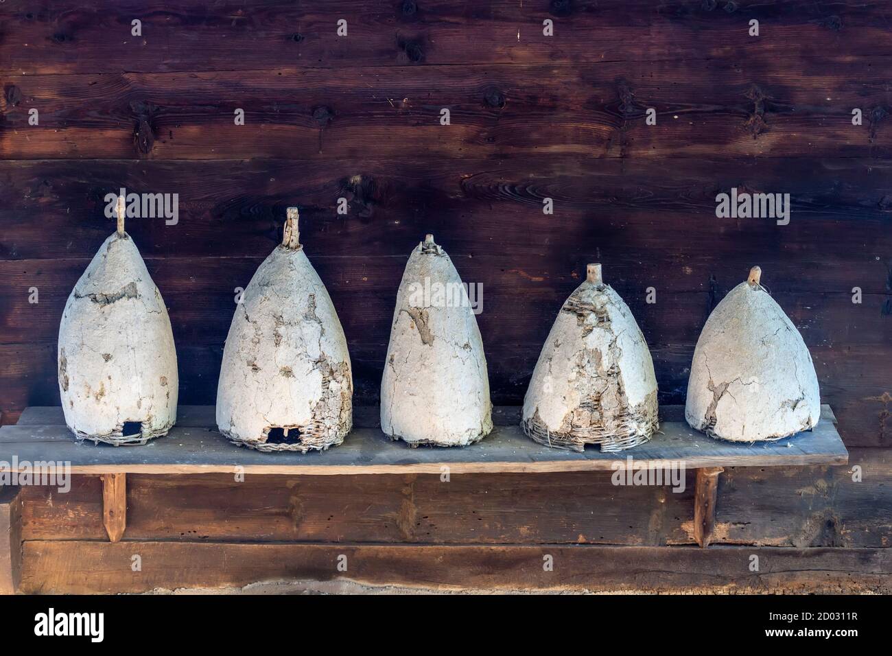 Fünf alte Bienenstöcke auf einer Reihe im Ethno-Dorf Sirogojno, Serbien. Stockfoto