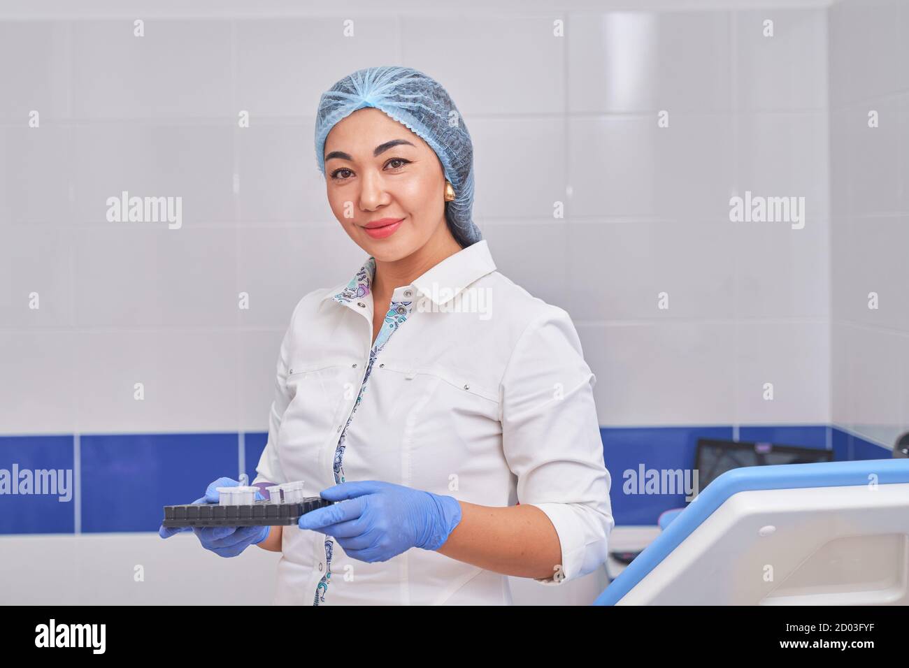 Asiatische Frauenärztin in einem weißen Mantel mit Tests Stockfoto