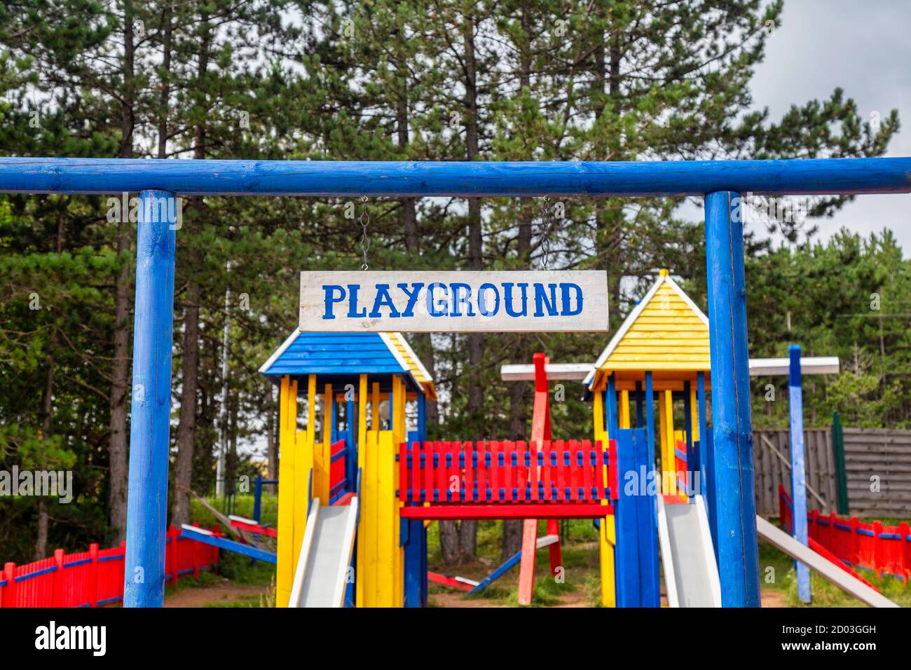 Holzspielplatz für Kinder, umgeben von grünen Bäumen. Konzentrieren Sie sich auf das Holzbrett. Stockfoto