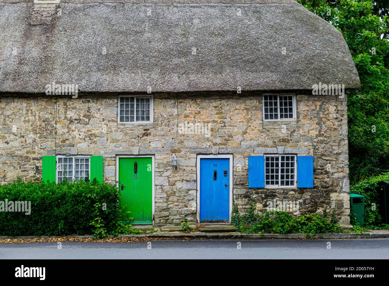 West Lulworth, Vereinigtes Königreich - 19 July 2020: Schönes reetgedeckte Häuschen mit blau und grün gefärbten Türen und Fensterläden, einzigartige Dorset colorfull Stockfoto