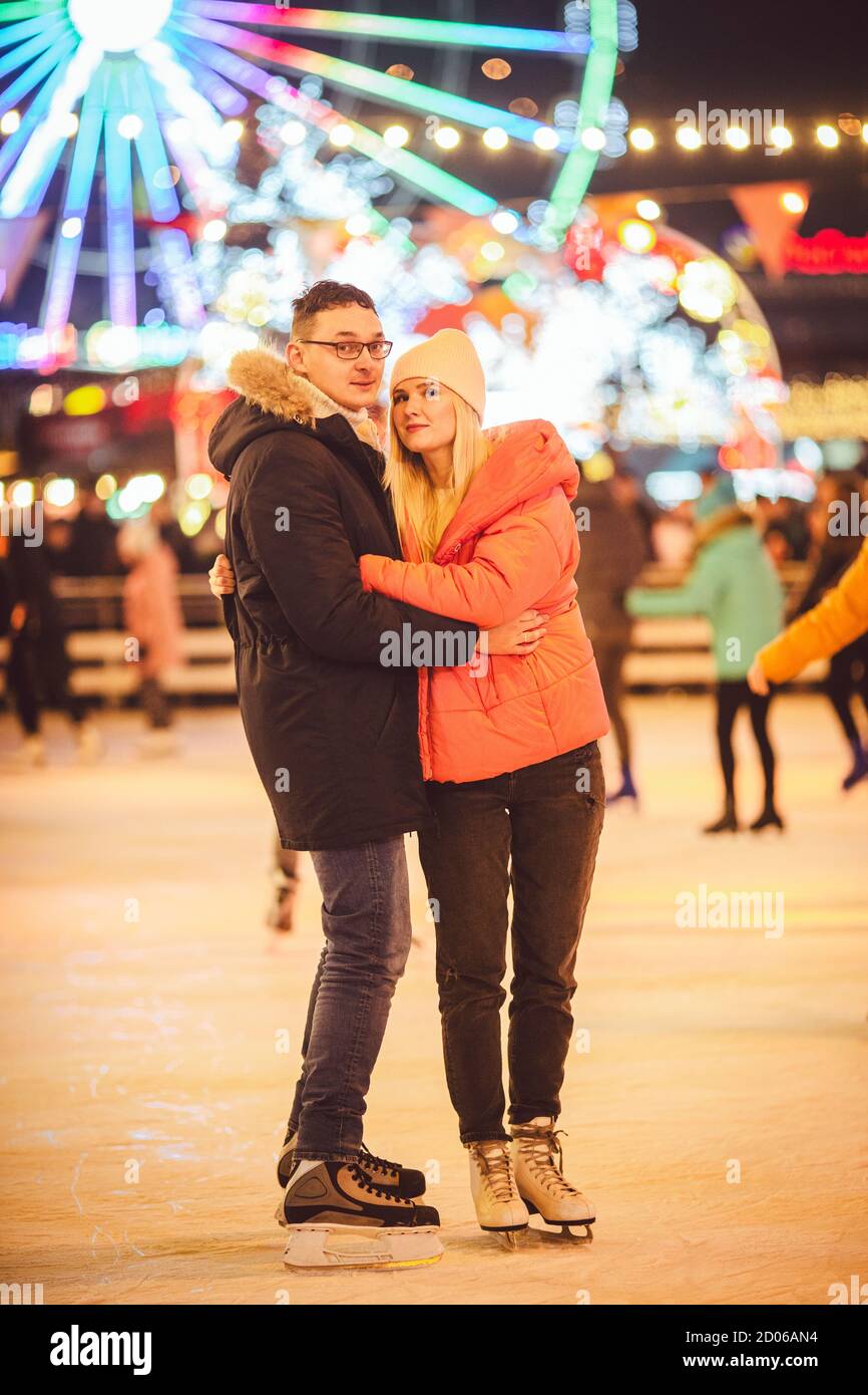 Gemeinsam Schlittschuhlaufen. Romantischer Winterurlaub in der Eisarena. Junges Paar Schlittschuhlaufen auf der Eisbahn. Das beste Weihnachten überhaupt. Winterspaß. Süßer Valentinstag Stockfoto