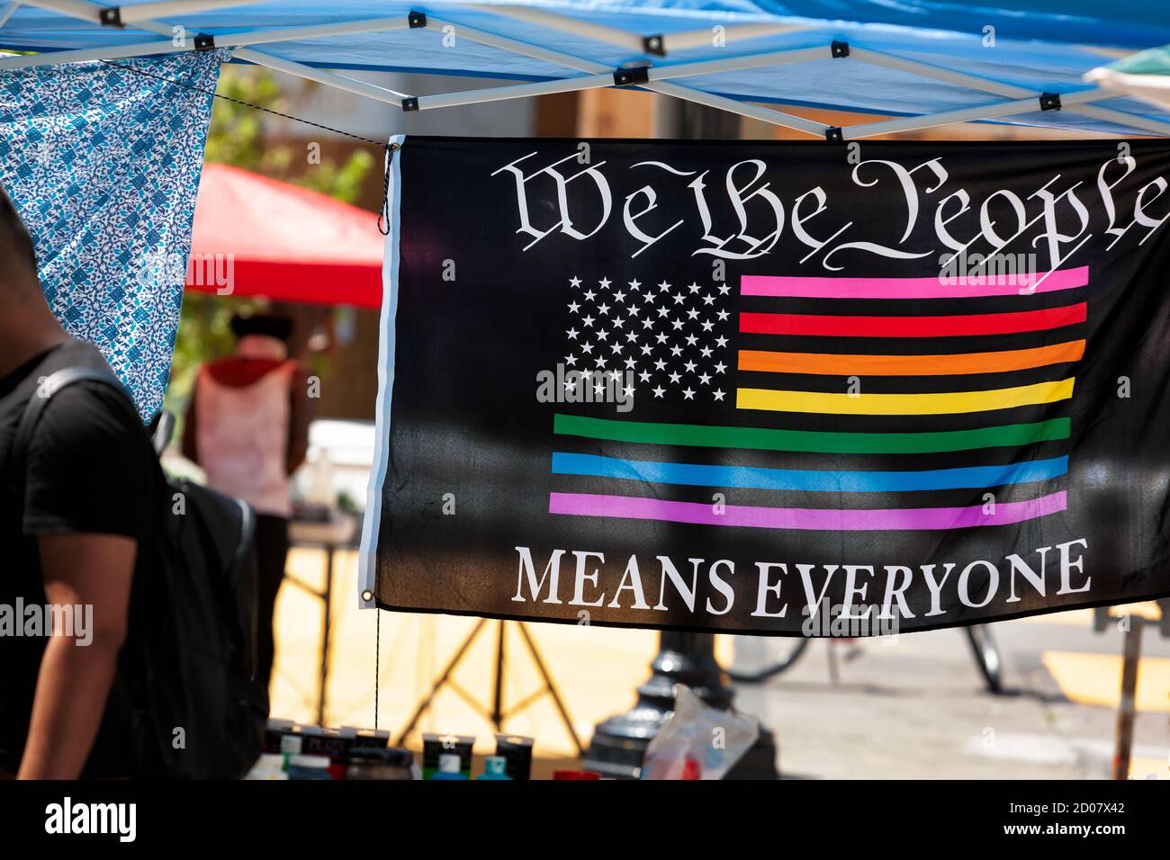 Eine Fahne, die einen Kunstprotest hängt, sagt: "Wir das Volk bedeutet alle" und zeigt eine amerikanische Flagge in Regenbogenfarben, Washington, DC, USA Stockfoto