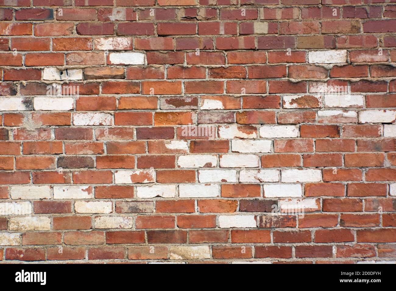 Verwitterte rote und weiße Backsteinwand Hintergrund in abstrakten Mustern. Stockfoto