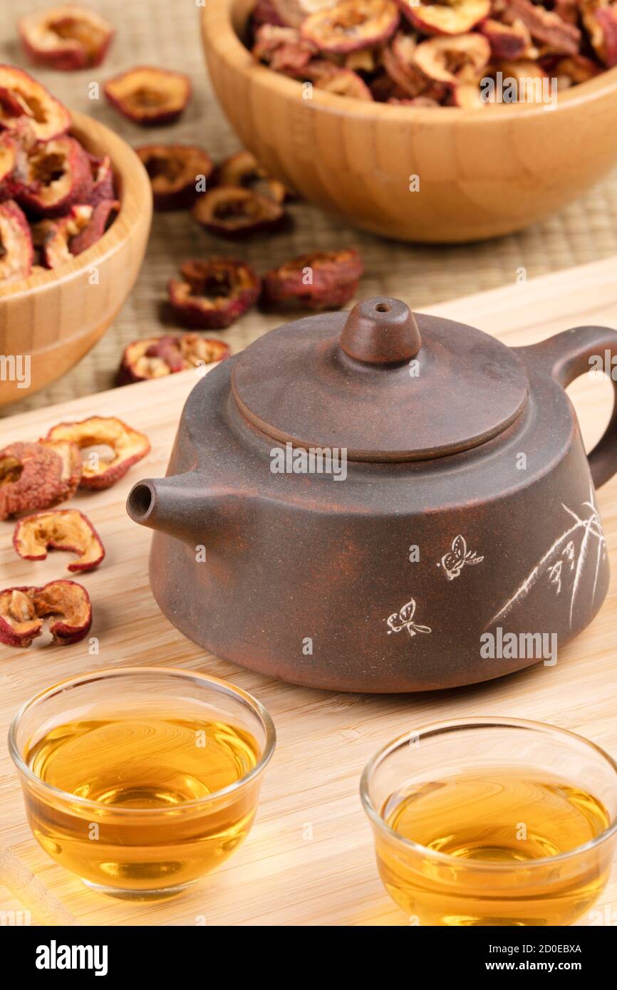 Nahaufnahme der traditionellen chinesischen Teekanne und Weißdornfrucht Tee isoliert auf Holzhintergrund Stockfoto