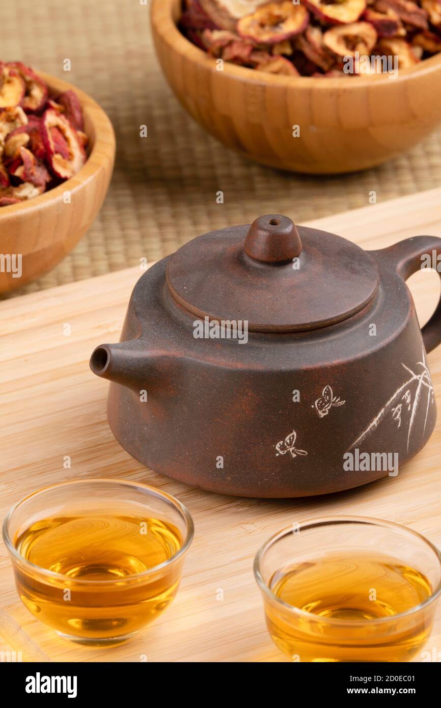 Nahaufnahme der traditionellen chinesischen Teekanne und Weißdornfrucht Tee isoliert auf Holzhintergrund Stockfoto