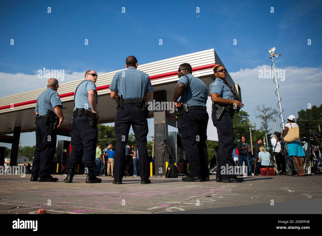 Polizisten stehen nach der Bekanntgabe des Namens des Offiziers an der Erschießung von Michael Brown in Ferguson, Missouri 15. August 2014 beteiligt. Polizeichef Thomas Jackson am Freitag identifiziert Darren Wilson als der Polizist, tödlich schießen eine unbewaffnete schwarze Teenager die Tage manchmal gewalttätigen Demonstrationen führte. Jackson kündigte den Namen bei einer Pressekonferenz in der Nähe ein QuikTrip Convenience-Store, die inmitten Proteste verbrannt worden war, über die Dreharbeiten von Braun, 18, am vergangenen Samstag. REUTERS/Lucas Jackson (Vereinigte Staaten - Tags: Unruhen Verbrechen Gesetz) Stockfoto