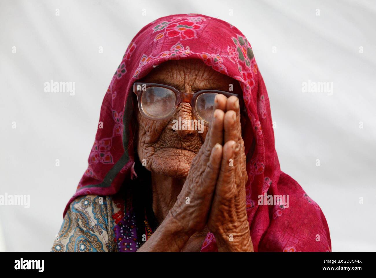 Zaib UN Nisa, eine hundertjährige Frau, die von Überschwemmungen vertrieben wurde, schließt sich ihren Handflächen an, um um Hilfe zu bitten, während sie mit anderen in einem Hilfslager für Flutopfer in Dadu, etwa 320 km (199 Meilen) nördlich von Karachi, am 11. Oktober 2010 Zuflucht sucht. REUTERS/Akhtar Soomro (PAKISTAN - Tags: KATASTROPHENBILDER DES TAGES) Stockfoto