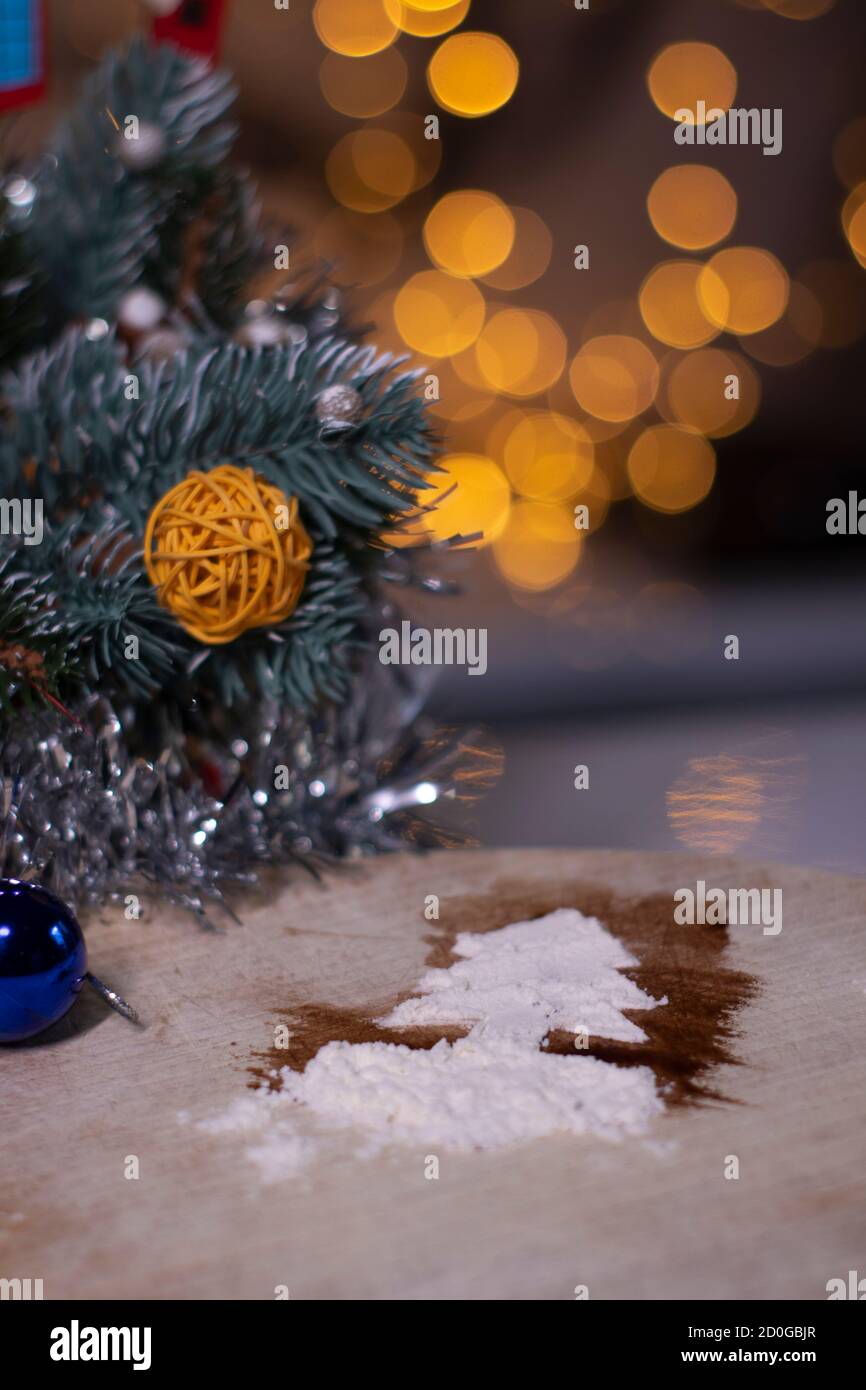 weihnachtsbaum aus Schnee auf einem Holzbrett neben den Weihnachtsdekorationen. Stockfoto