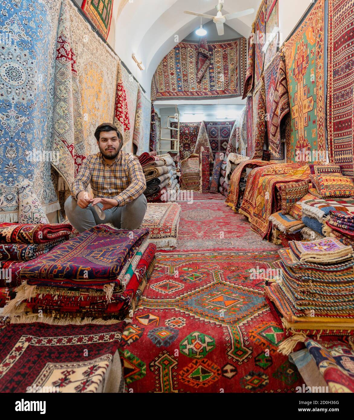 Shiraz, Iran - 2019-04-08-Mann sitzt in seinem Teppich Teppich speichern. Stockfoto