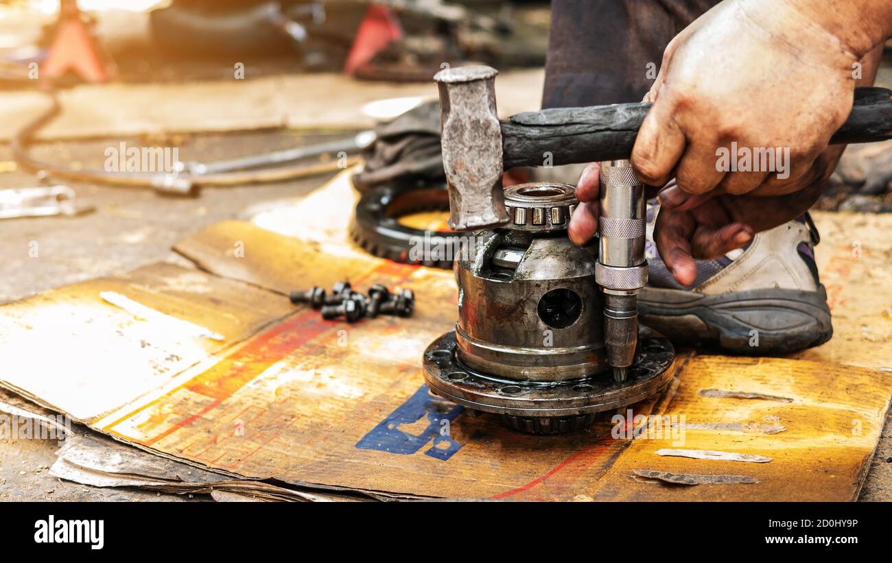 Techniker verwenden die Werkzeuge, um die Zahnräder der Antriebswelle von Autos zu demontieren, um Ersatzteile zu machen und zu reparieren. Stockfoto