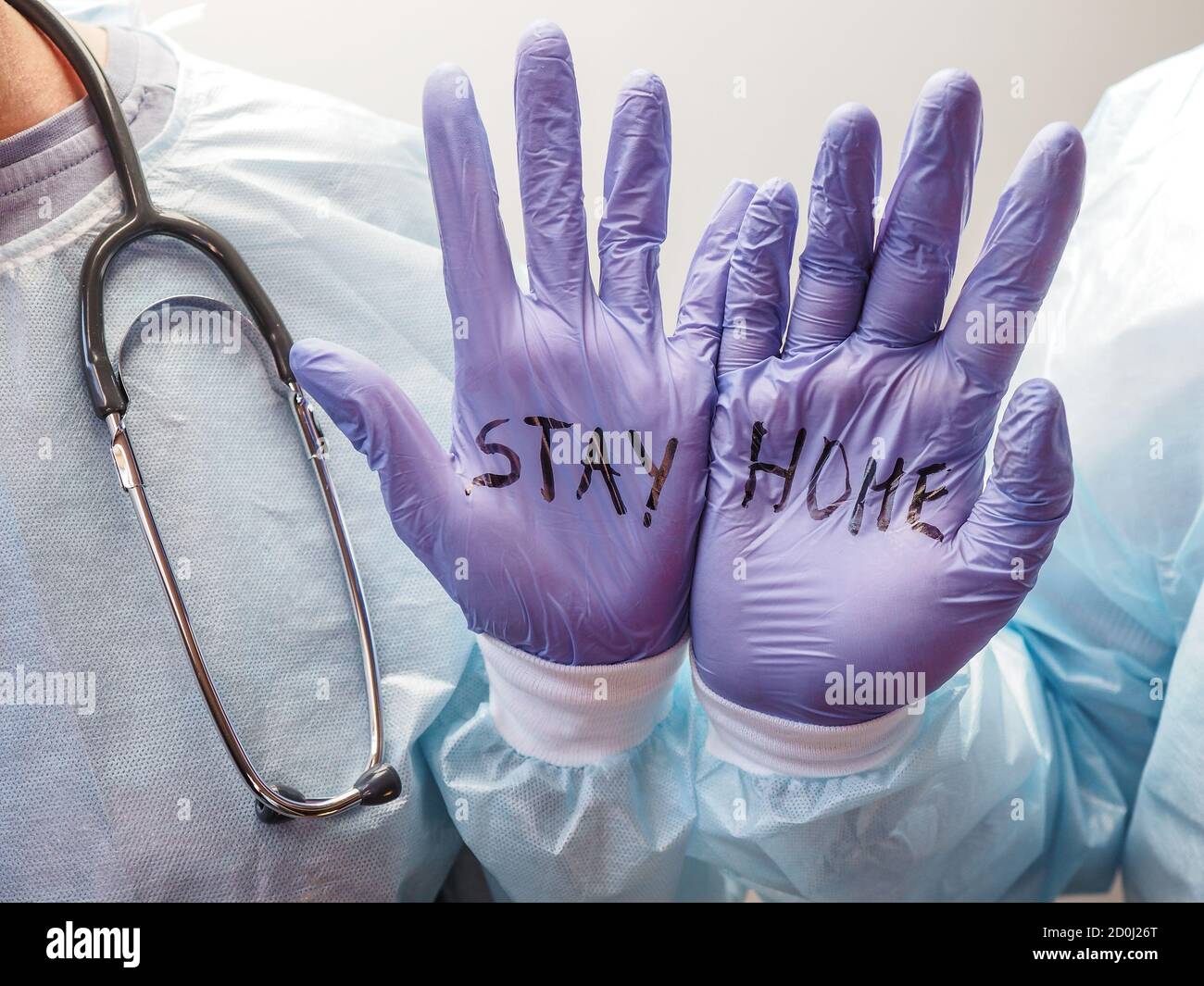 Zwei Ärzte halten ihre Hände aus und sagen den Leuten, dass sie bleiben sollen Zu Hause Stockfoto