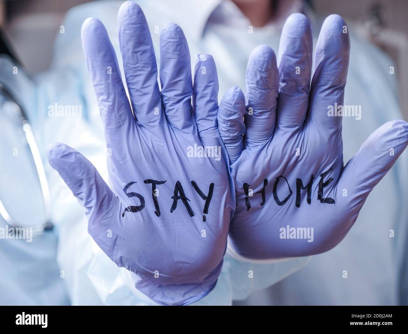 Zwei Ärzte halten ihre Hände aus und sagen den Leuten, dass sie bleiben sollen Zu Hause Stockfoto