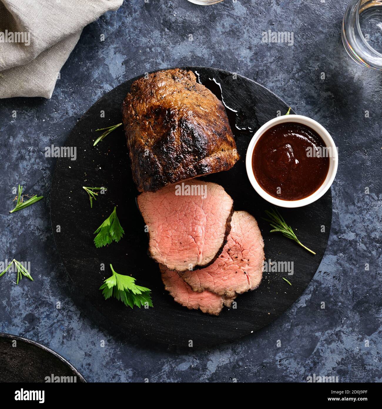 Nahaufnahme von gegrilltem Rindfleisch auf Holzbrett über Stein Hintergrund. Mittelseltenes Roastbeef. Draufsicht, flach liegend Stockfoto