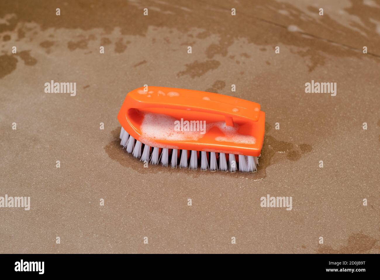Eine orangefarbene Poliermatte aus Kunststoff zum Reinigen von Böden, Wänden oder allgemeinen Geräten. Stockfoto
