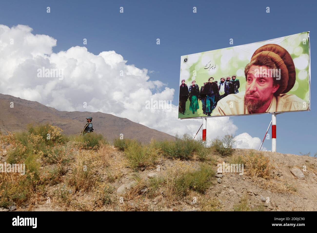 Ein afghanischer Polizist steht neben einem Bild des getöteten Nationalhelden Ahmad Shah Masood auf dem Denkmal, das zu seinem 11. Todestag in der Provinz Panjshir am 9. September 2012 errichtet wurde. Masood, oder der Löwe von Panjschir, kämpfte gegen die Taliban an der Spitze der Nordallianz, die die ethnischen Minderheiten Afghanistans vertritt, bis zu seiner Ermordung zwei Tage vor den Anschlägen vom 11. September 2001. REUTERS/Mohammad Ismail (AFGHANISTAN - Tags: JUBILÄUMSGESELLSCHAFT) BESTE QUALITÄT ZUR VERFÜGUNG Stockfoto