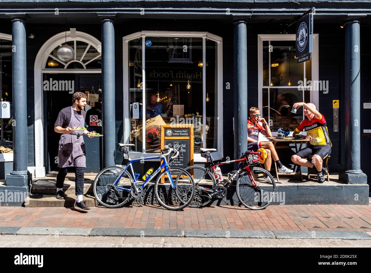 Zwei Radfahrer, die eine Pause vor EINEM Cafe, High Street, Lewes, East Sussex, Großbritannien. Stockfoto