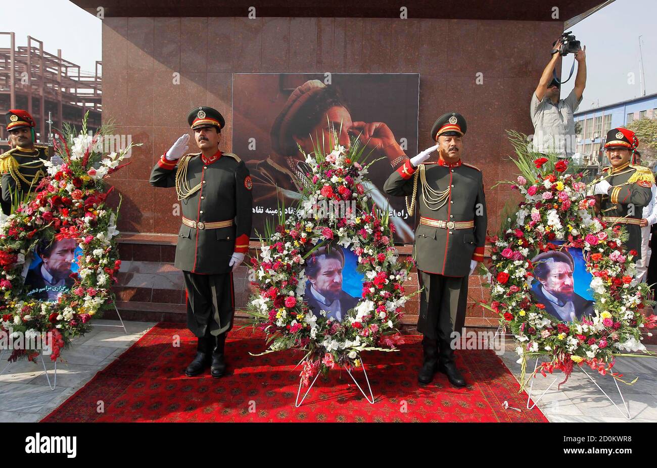 Eine afghanische Ehrengarde steht neben einen Kranz aus Blumen anlässlich der 10. Todestag des ermordeten afghanischen Nationalhelden Ahmad Shah Masood in Kabul 9. September 2011. Massoud oder Löwe von Panjshir gekämpft die Taliban an der Spitze der Nordallianz Afghanistans ethnischen Minderheiten, bis zu seiner Ermordung zwei Tage vor den Anschlägen des 11. September 2001 vertreten.  REUTERS/Omar Sobhani (AFGHANISTAN - Tags: Politik Jubiläum Unruhen) Stockfoto