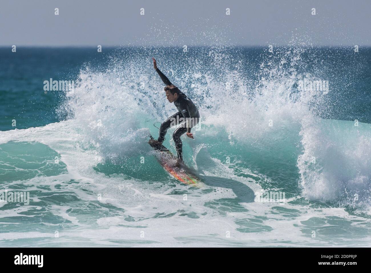 Spektakuläre Action, während ein junger Surfer eine Welle im Fistral in Newquay in Cornwall reitet. Stockfoto