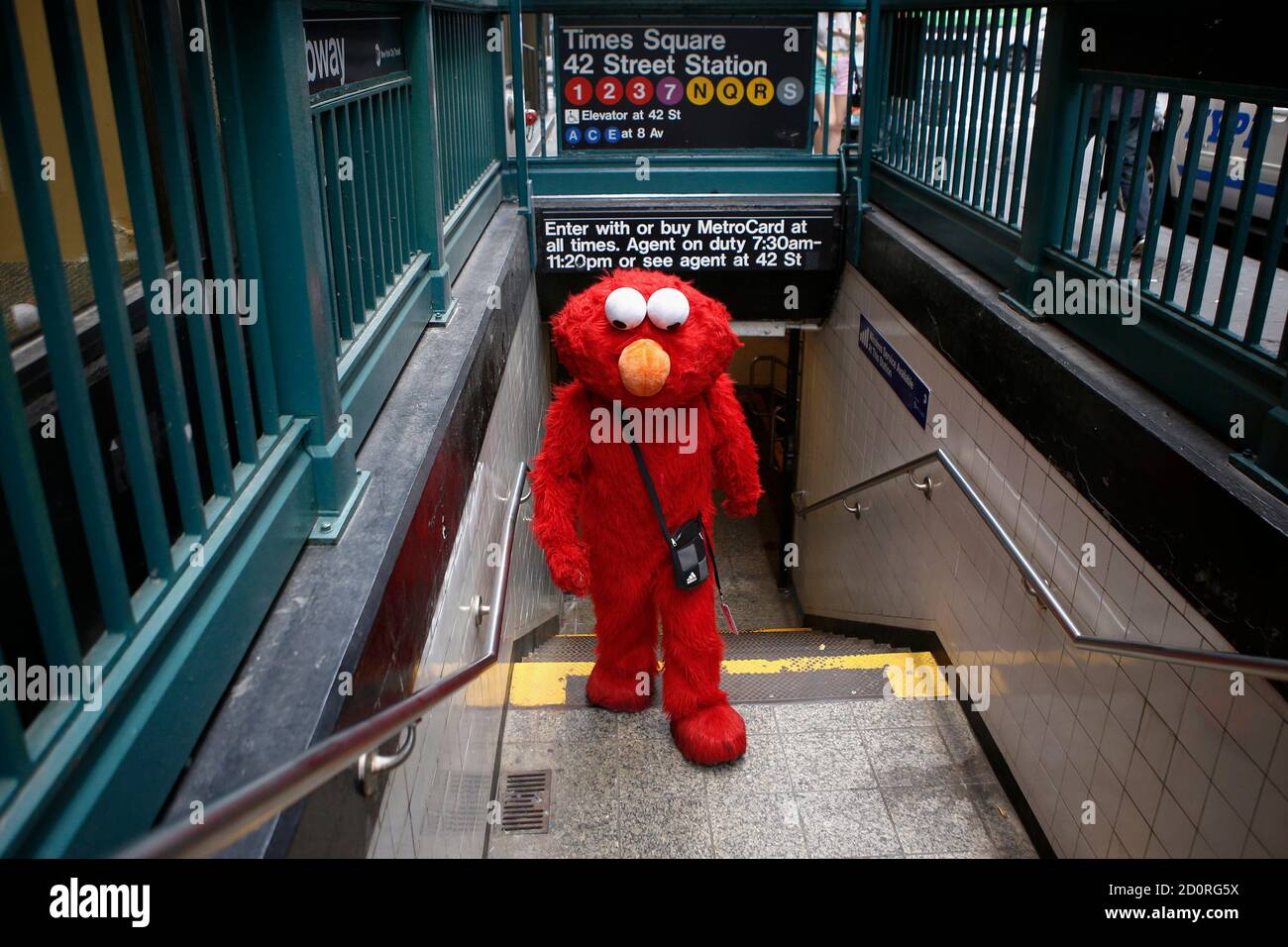 Jorge, ein Einwanderer aus Mexiko, wird eine u-Bahnstation gekleidet als  Zeichen Sesamstraße Elmo am Times Square, New York 30. Juli 2014 beendet.  Elmo und Krümelmonster haben lange begeistert junge Zuschauer am TV "