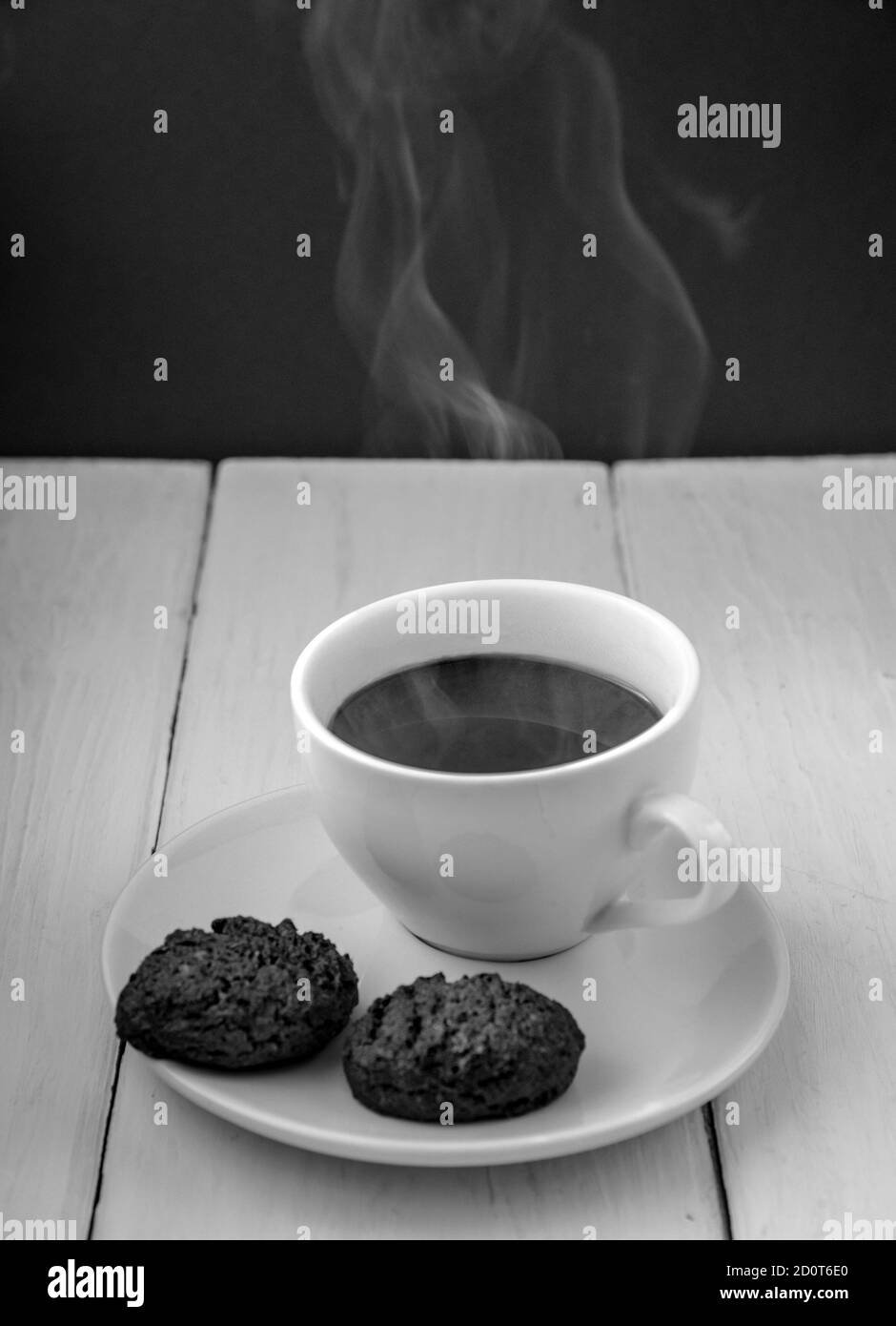 Tasse heißen Espresso und Cookies auf dem Holztisch, selektiver Fokus, vertikale Zusammensetzung Stockfoto