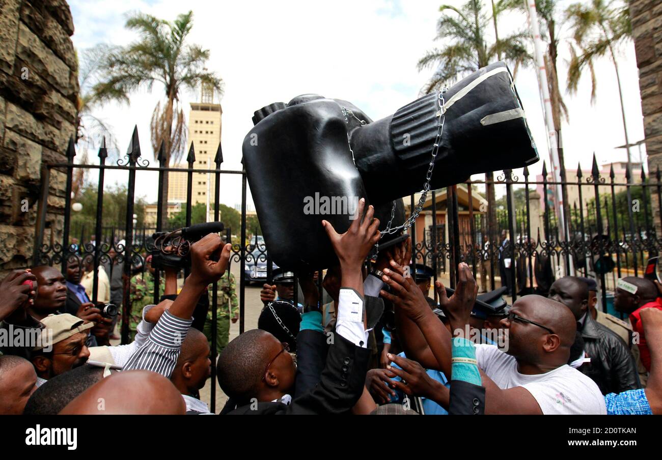 Kenianische Journalisten und Bürgerrechtler tragen eine plastische Nachbildung einer Kamera zum Haupttor des Parlaments, wie sie an einer Protestkundgebung in der Hauptstadt Nairobi, 3. Dezember 2013 teilnehmen. Mitglieder der kenianischen Medien marschierten in einem friedlichen Protest, der neue drakonische Gesetze des Parlaments zu verurteilen. Kenias Präsident sein Veto gegen ein Gesetz, das verhängt Geldbußen und Beschränkungen für Journalisten, sagte, es sei verfassungswidrig, das erste Mal hat er seine Kraft verwendet, Rechtsvorschriften abzulehnen wäre. Kritiker sagen, in der Rechnung festgelegten Regeln würde investigativen Berichte über Korruption, der kenianischen Bevölkerung plagen Einhalt zu Gebieten Stockfoto