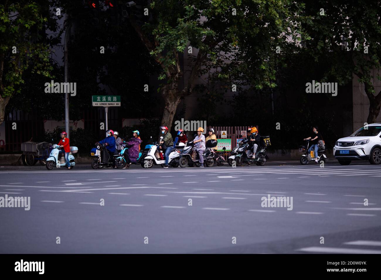 Huzhou, China 2020 September 28: Elektro-Scooter und Auto Rush Hours City Street. Autos auf der Straße im Stau auf Fußgänger Stockfoto