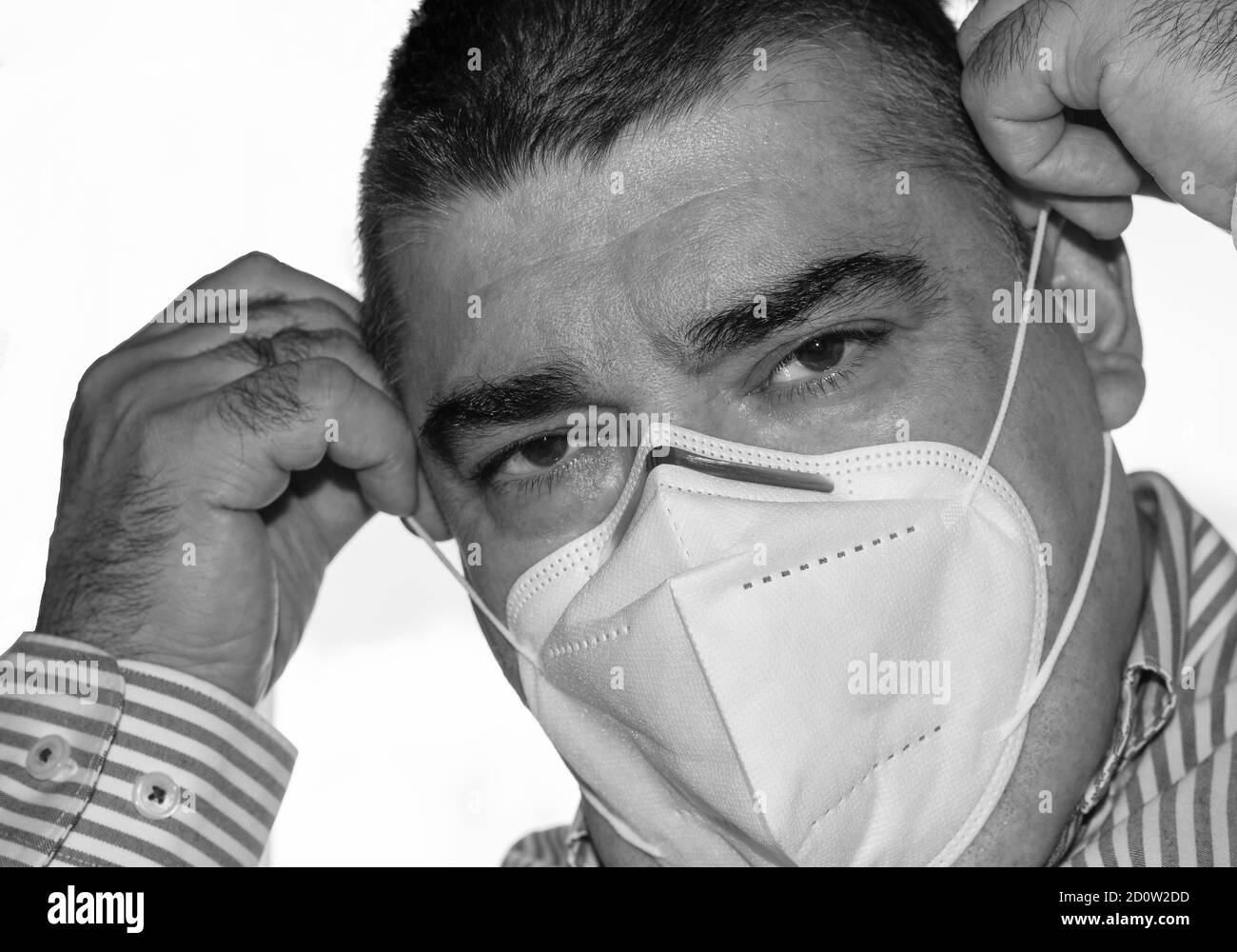 50-Jährige trägt eine weiße Schutzmaske gegen Coronavirus Stockfoto