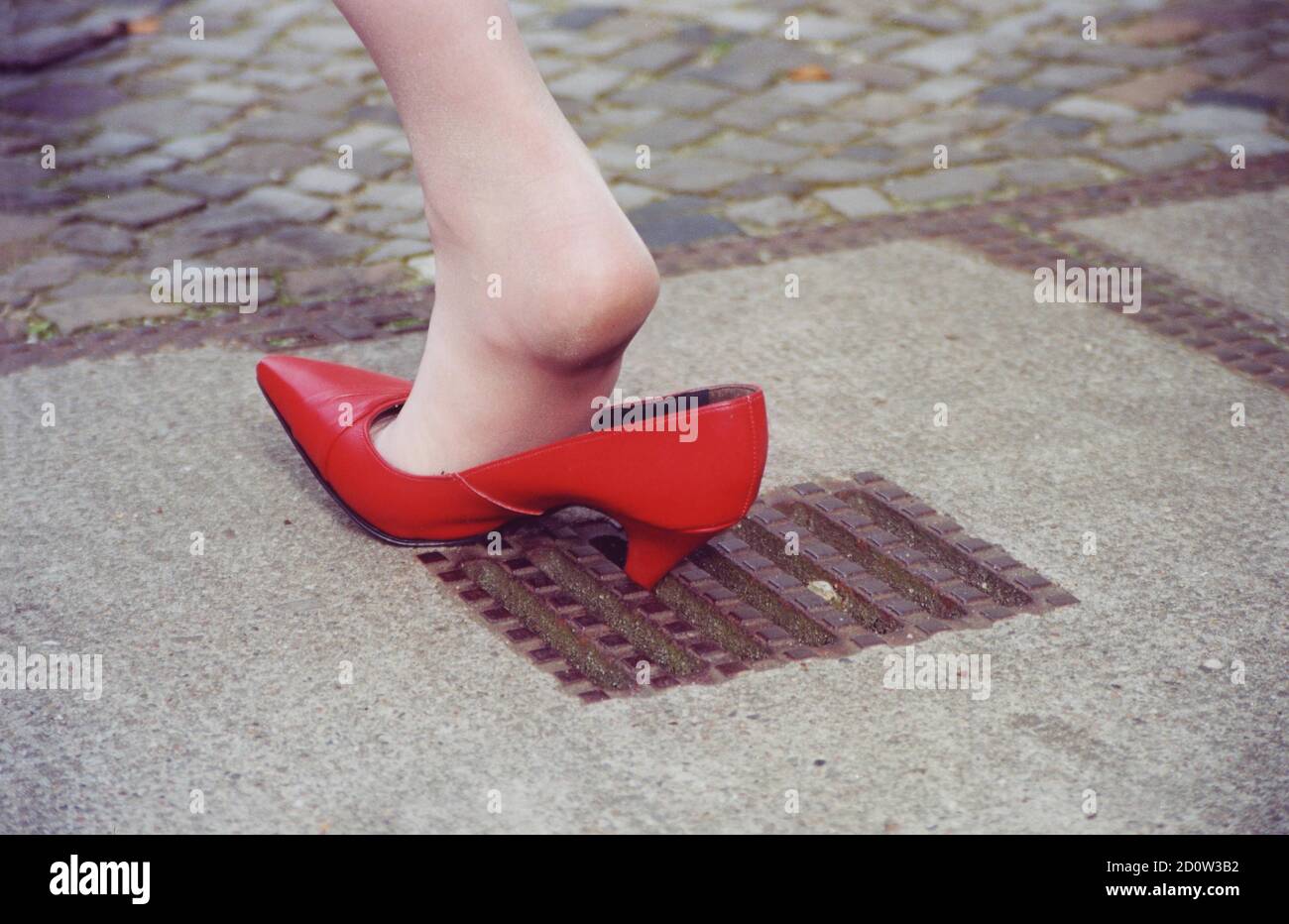 Unglück, Frau steckt in einem Loch mit High Heels, Berlin, Deutschland, Europa Stockfoto
