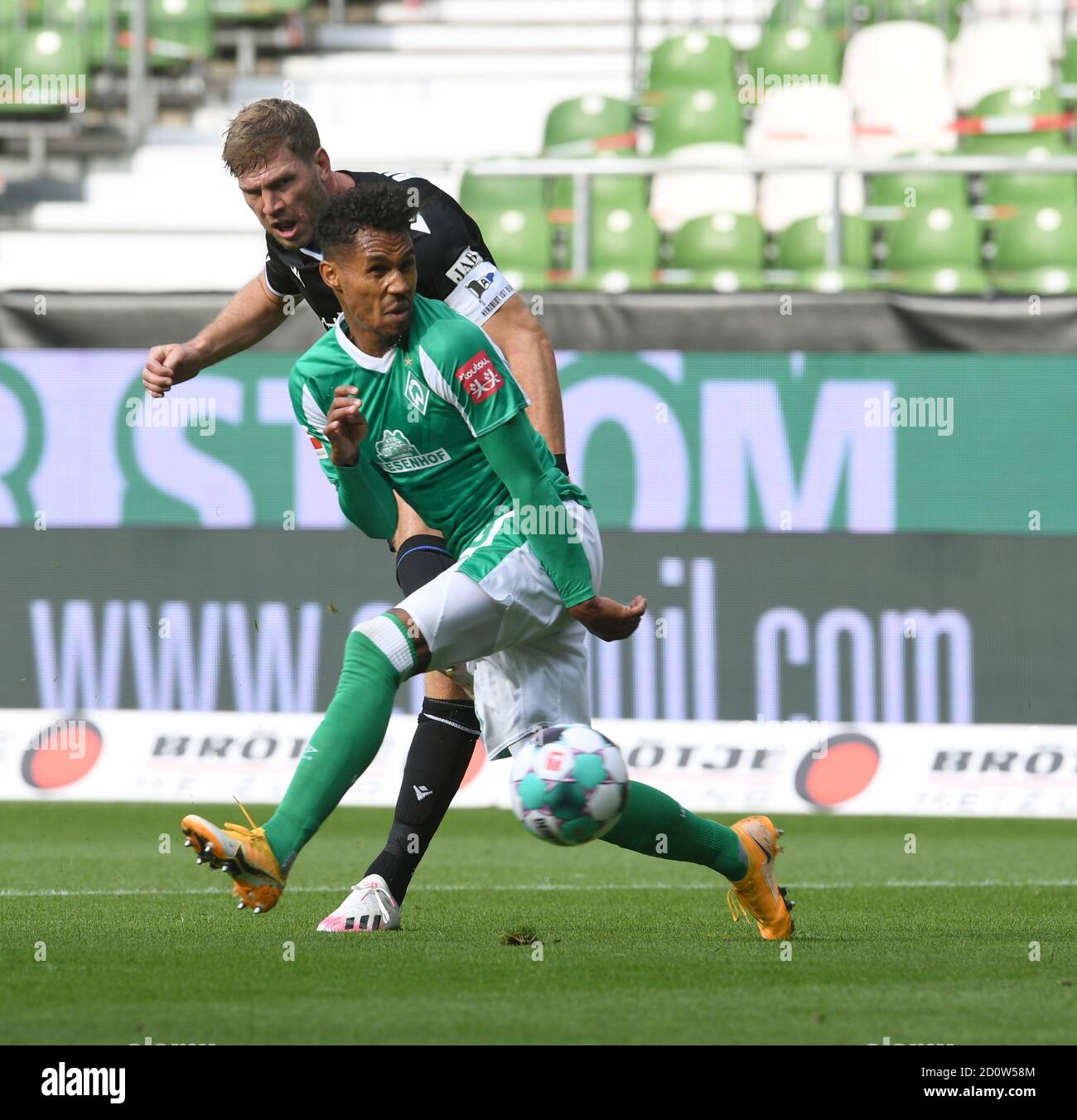 Bremen, Deutschland. Oktober 2020. Fußball: Bundesliga, Werder Bremen - Arminia Bielefeld, 3. Spieltag. Werders Theodor Gebre Selassie (vorne) kann den Bielefelder Fabian Klos nicht daran hindern, den Schuss zu machen. Kredit: Carmen Jaspersen/dpa - WICHTIGER HINWEIS: Gemäß den Bestimmungen der DFL Deutsche Fußball Liga und des DFB Deutscher Fußball-Bund ist es untersagt, im Stadion und/oder aus dem Spiel aufgenommene Aufnahmen in Form von Sequenzbildern und/oder videoähnlichen Fotoserien zu nutzen oder auszunutzen./dpa/Alamy Live News Stockfoto