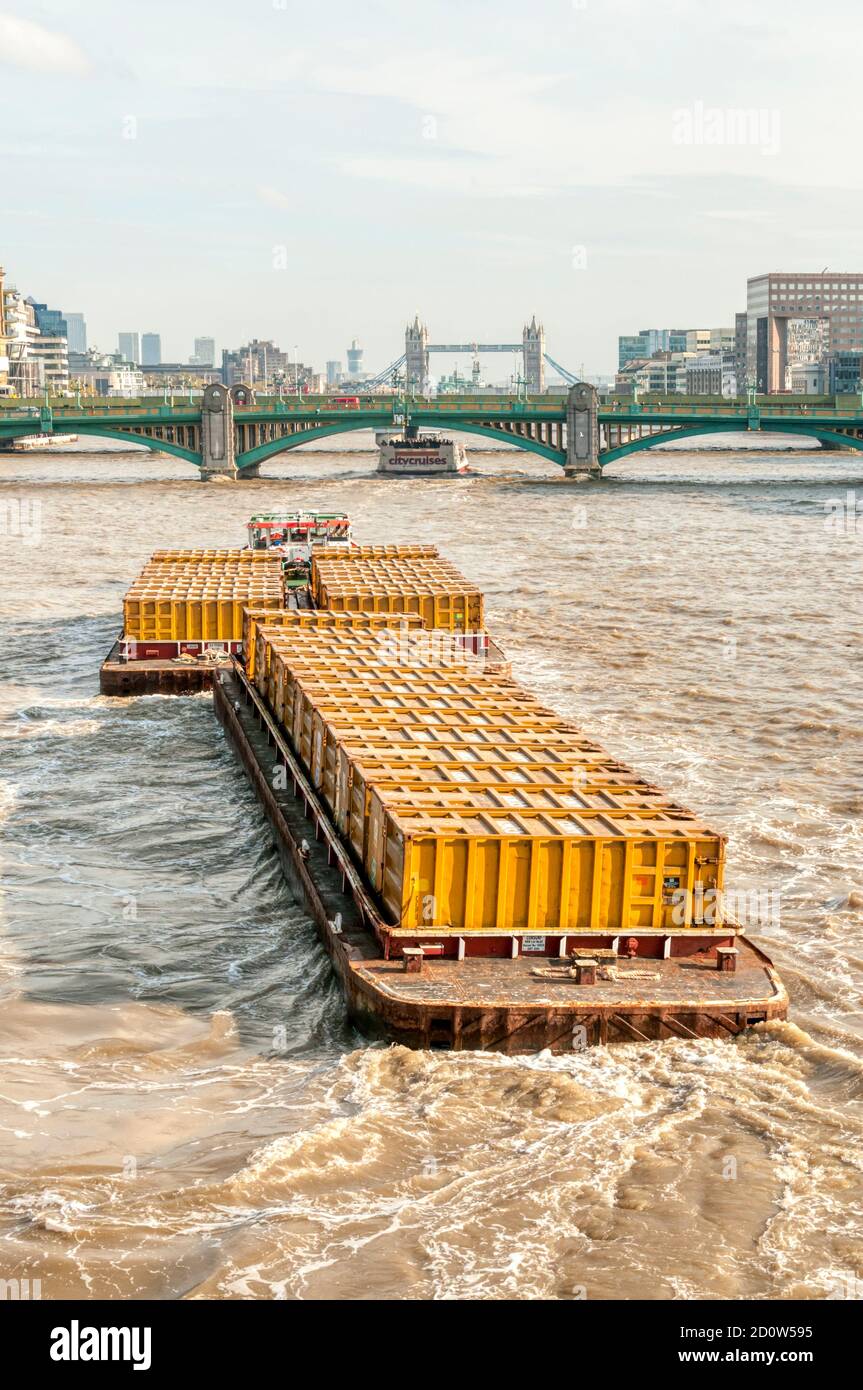 Der Cory Riverside Schlepper Reclaim schleppt eine Ladung containerisiertem Müll auf Lastkähne entlang der Themse im Zentrum von London. Stockfoto