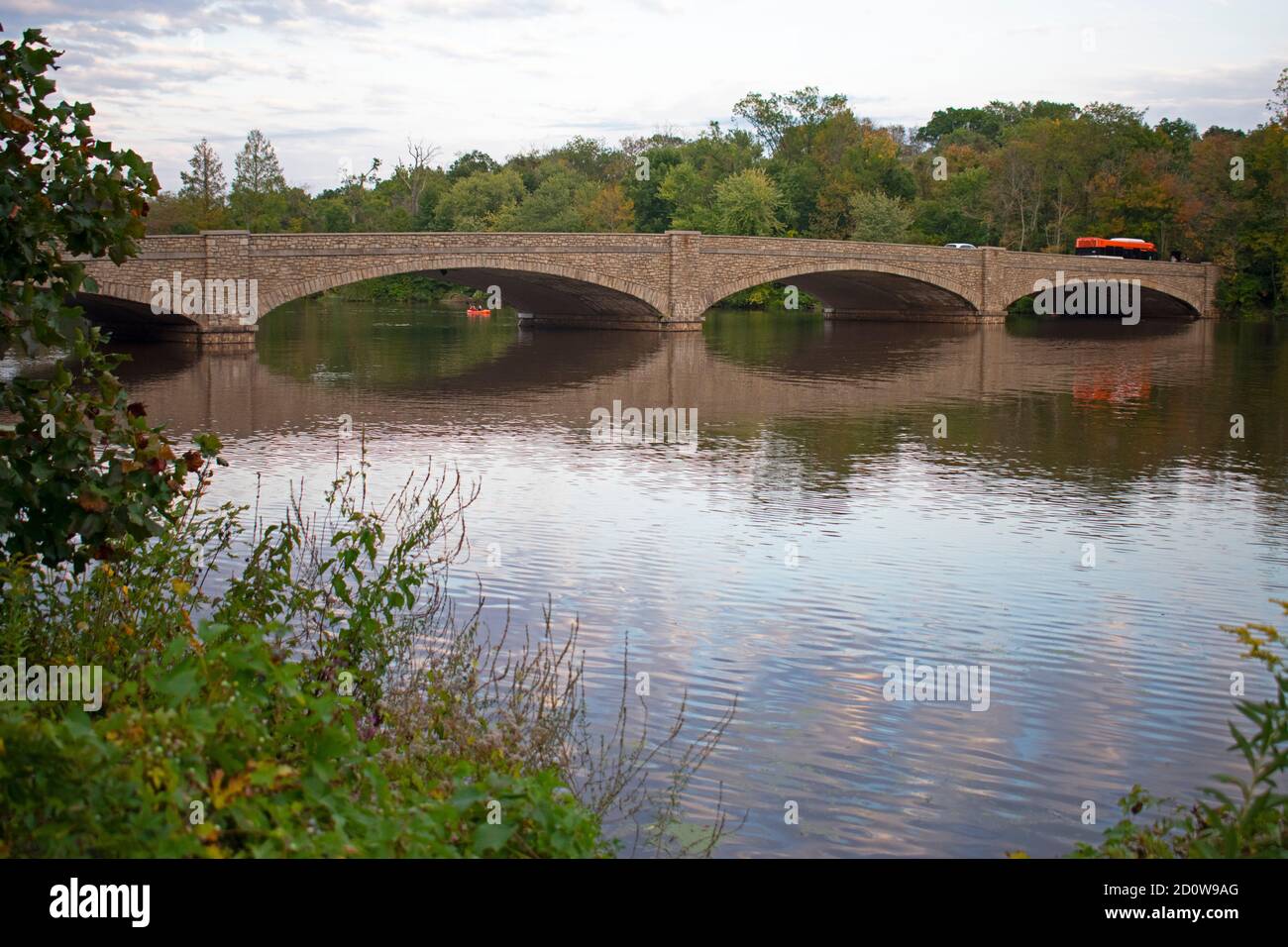 Spiegelungen einer Straßenbrücke, Vegetation und wolkiger Himmel im Delaware und Raritan Canal State Park in Princeton, New Jersey, USA -05 Stockfoto