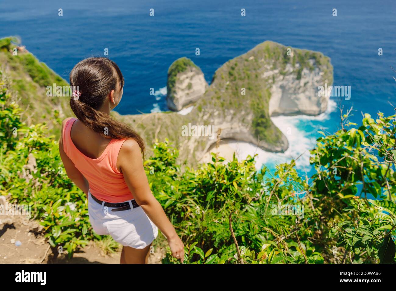 Frau bleibt auf einem hohen Felsen und blickt aufs Meer. Kelingking Beach, Nusa Penida, Indonesien. Stockfoto