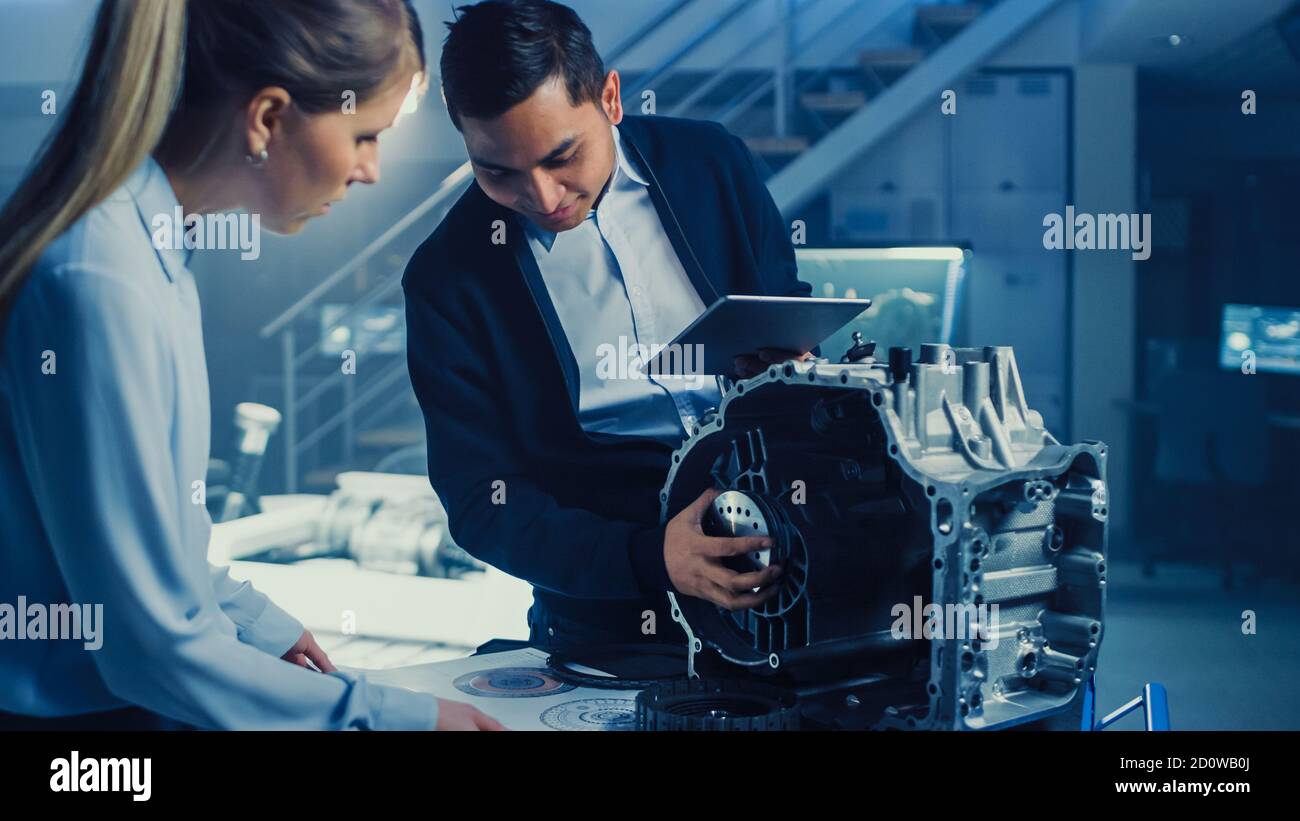 Entwicklungslabor mit einem professionellen Konstruktionsingenieur für die Automobilindustrie, der an einem Getriebe für Elektrofahrzeuge arbeitet. Fahrgestell mit Rädern, Batterien Stockfoto